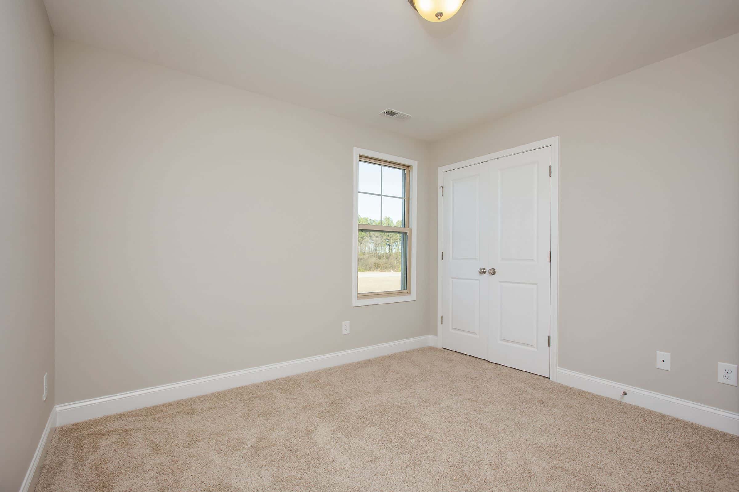 Empty Bedroom with closet and carpet